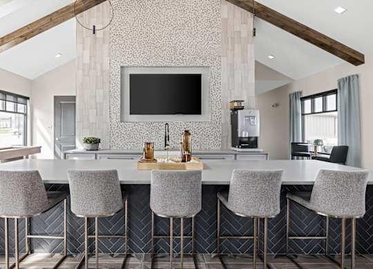 a kitchen with a marble counter top and chairs