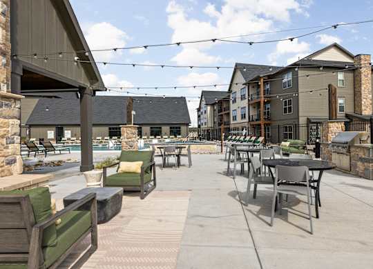 an outdoor patio with tables and chairs at the residences at town center apartments
