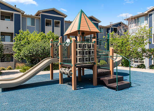 A playground with a slide and a wooden structure.