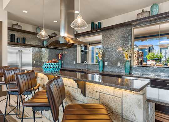 A kitchen with a bar area and chairs.