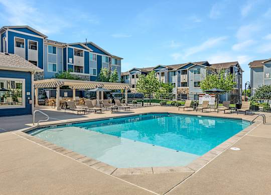 A swimming pool in front of apartment buildings.
