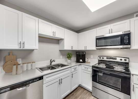 A kitchen with white cabinets and stainless steel appliances.