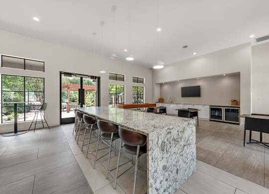 A modern kitchen with a bar area and a view of the backyard.