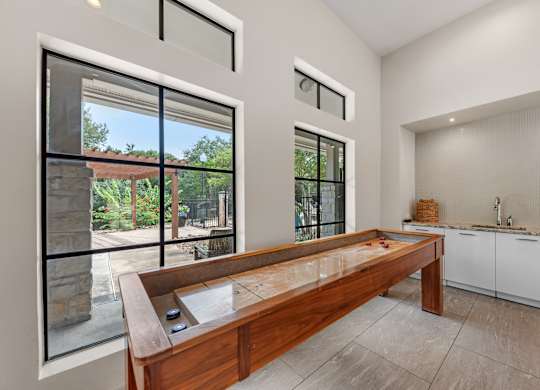 A table of shuffleboard in a corner of a modern clubhosuse
