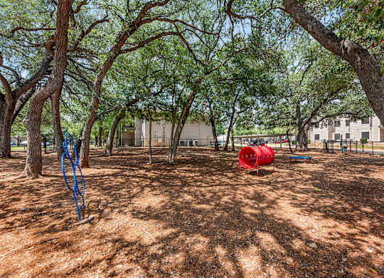 A dog park with a red barrel.