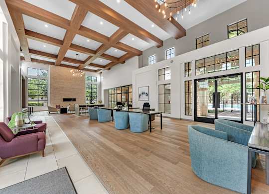 A spacious living room with a high ceiling and wooden beams.