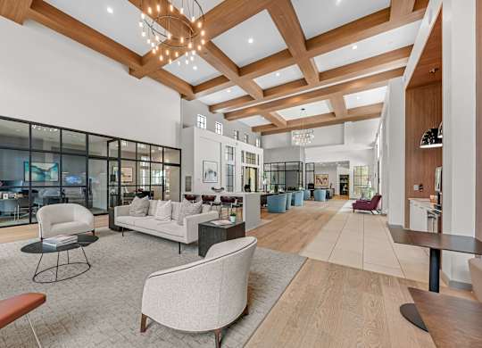 A spacious living room with a high ceiling and wooden beams.