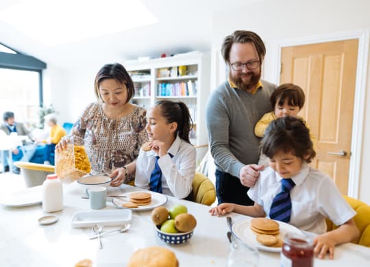 a family gathered around a table eating breakfast together