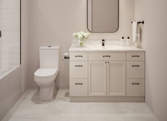 A white bathroom with a toilet, sink, and mirror.