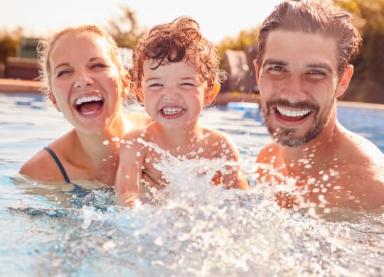 a man and woman with a child in a swimming pool