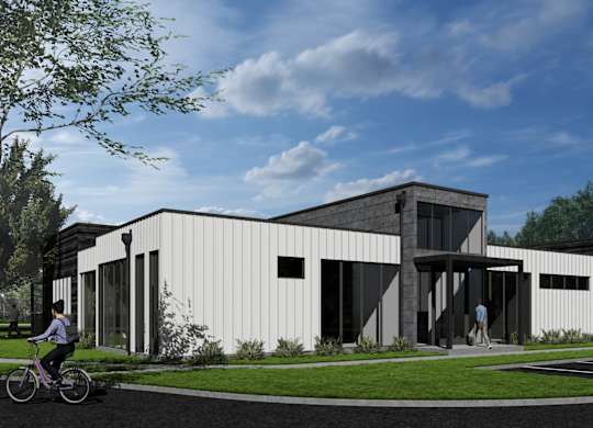 A modern building with a white exterior and a person riding a bicycle in front of it at  Aerie Heartwood Preserve in Omaha, NE