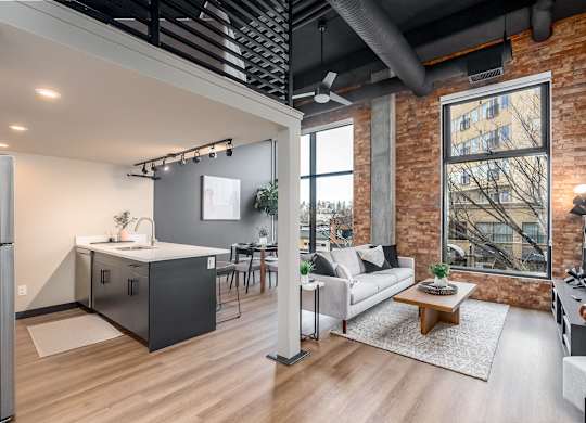 A modern kitchen with a refrigerator, sink, and a dining table with chairs.at Raymond Block, Edmonton