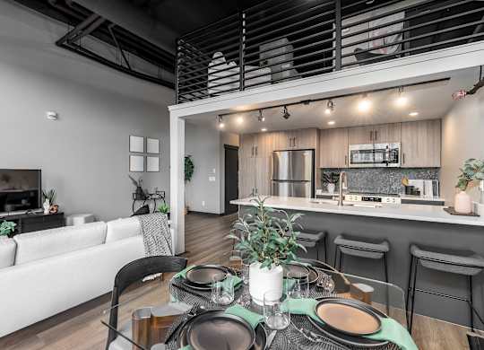 A modern dining area with a table set for a meal.at Raymond Block, Edmonton, T6E 3R7