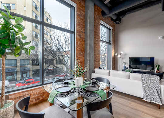 A modern living room with a glass table and a white couch.at Raymond Block, Alberta