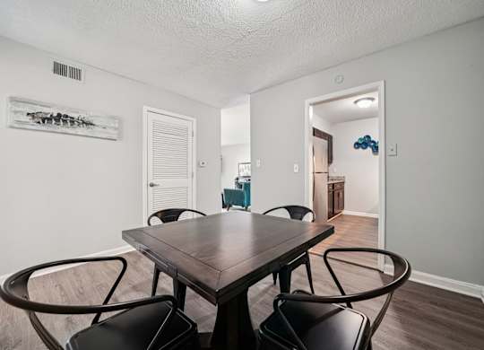 A dining room with a wooden table and chairs.