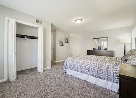 A bedroom with a bed, dresser, and mirror.