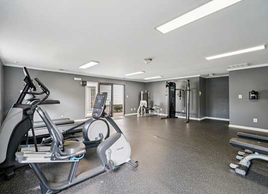 A spacious gym with a treadmill, elliptical trainer, and other exercise equipment.