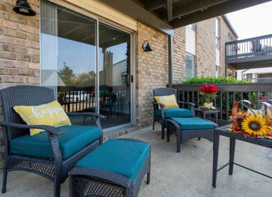 A patio with two chairs and a table with a sunflower on it at The Onyx Hoover Apartments, Alabama