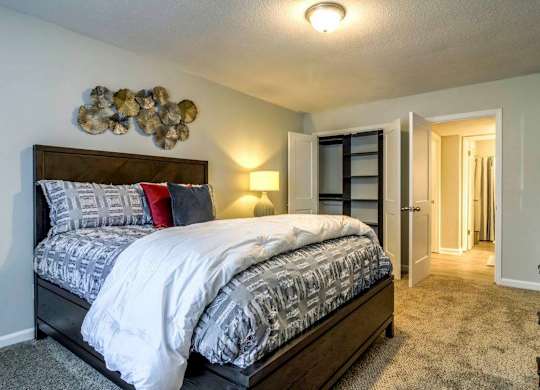 A bedroom with a large bed and a wall decoration at The Onyx Hoover Apartments, Hoover