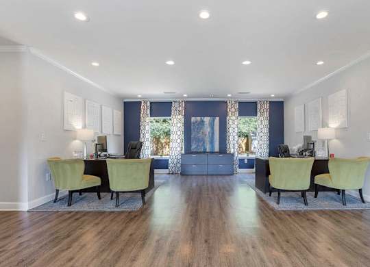 A spacious room with a desk and chairs in the foreground and a couch in the background at The Onyx Hoover Apartments, Hoover, Alabama