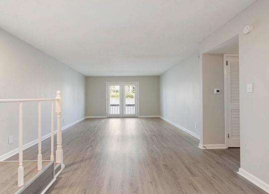 A spacious room with light wood flooring and white walls. at The Onyx Hoover Apartments, Hoover, AL, 35216