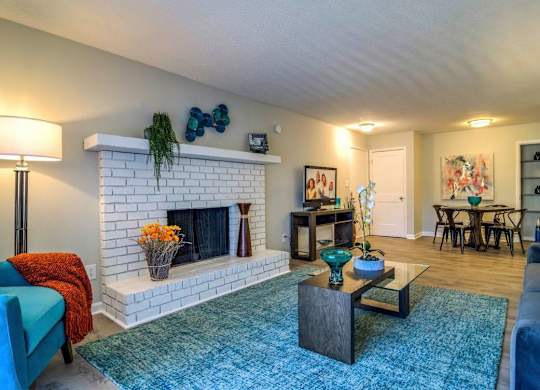 A living room with a fireplace and a blue couch at The Onyx Hoover Apartments, Hoover, AL, 35216
