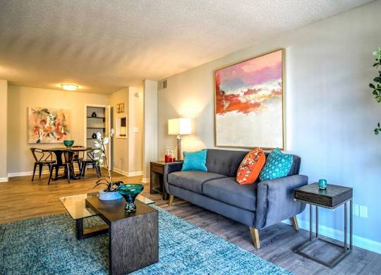 A living room with a grey couch, a coffee table, and a painting on the wall at The Onyx Hoover Apartments, Hoover, 35216