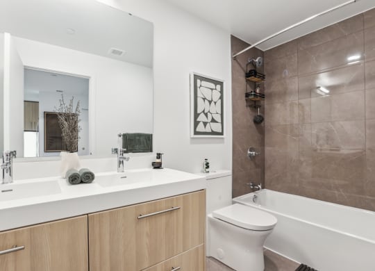 a bathroom with a large mirror and a toilet and a tub