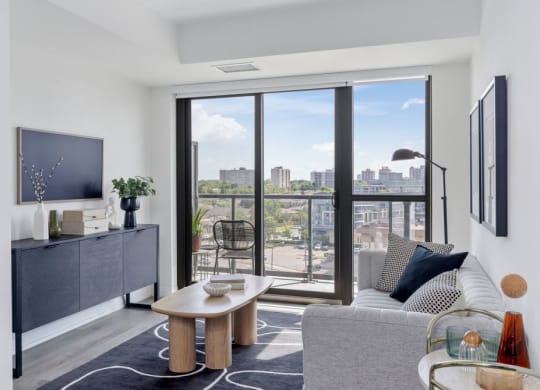 a living room with a view of the city and a couch and a table