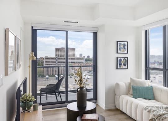 a living room with a couch and a balcony overlooking a city