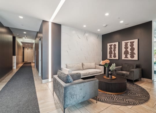 a lobby with couches and chairs and a rug