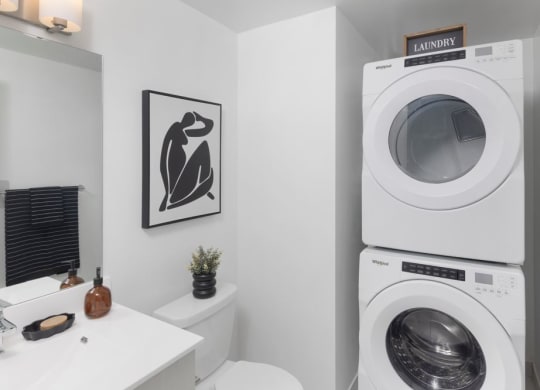 a bathroom with a washing machine and a sink and a geometric wallpaper