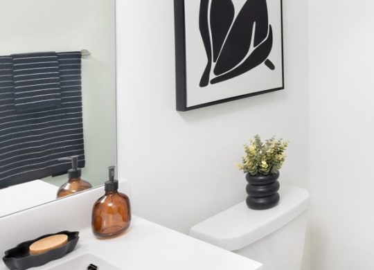 a white bathroom with a picture of a woman on the wall