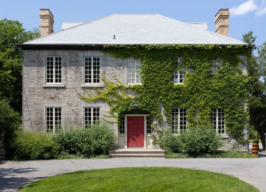 a house with a red door and ivy on the side of it
