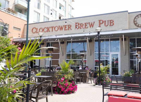 a view of the outside of the clocktower brew pub with tables and chairs