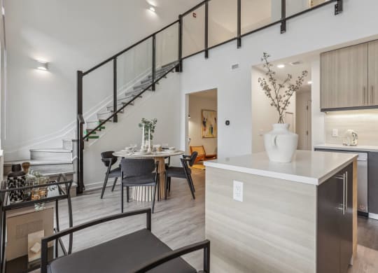 a kitchen with a dining area and a staircase in a house