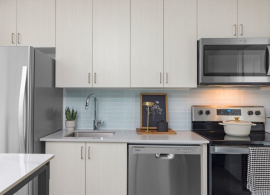 a kitchen with white cabinets and stainless steel appliances