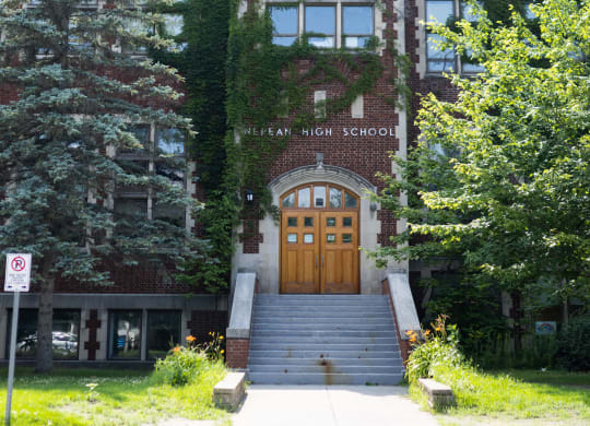 a large brick building with wooden doors and stairs in front of it