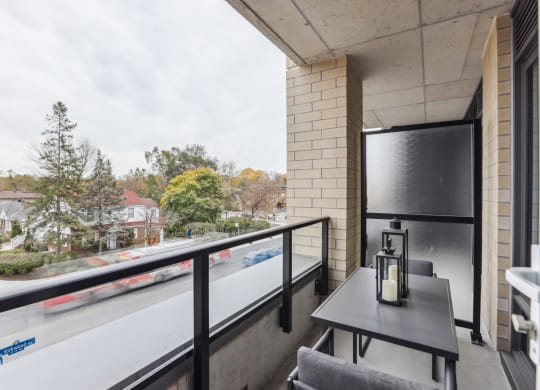 a balcony with a table and chairs and a large window