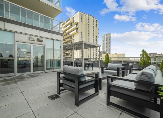 a large patio with chairs and tables and a building in the background