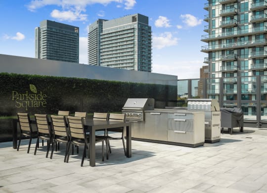 a communal terrace with a table and barbecue grill on a rooftop