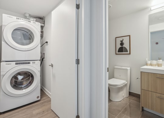 a washer and dryer in a bathroom next to a toilet and a sink