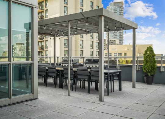 a communal terrace with tables and chairs under a canopy