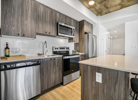 A modern kitchen with wooden cabinets and stainless steel appliances.