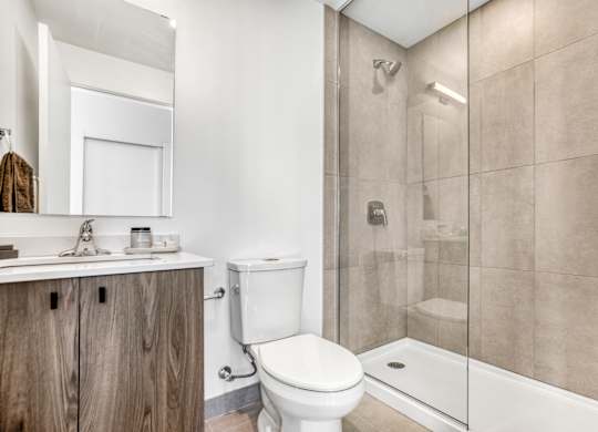 A bathroom with a toilet, sink, and shower.