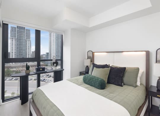 a bedroom with a bed and a large window
