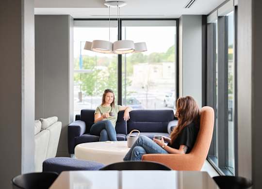Two women sitting in a modern lounge area.