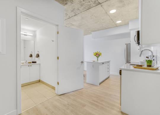 A kitchen with white cabinets and a wooden floor.