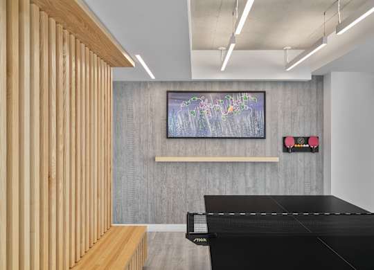 A room with a wooden panelled wall and a painting hanging on it.