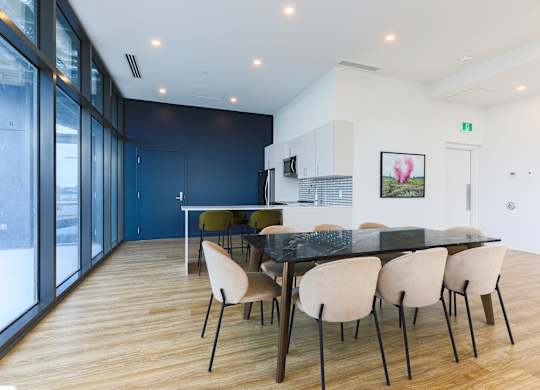 A modern dining room with a black table and chairs.